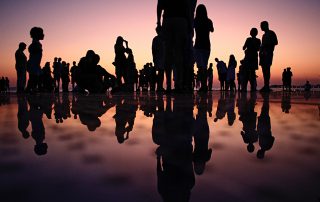 silhuetas de pessoas ao por do sol