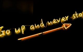 Neon com as palavras Go up and never stop