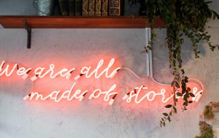 neon com a frase we are all made of stories