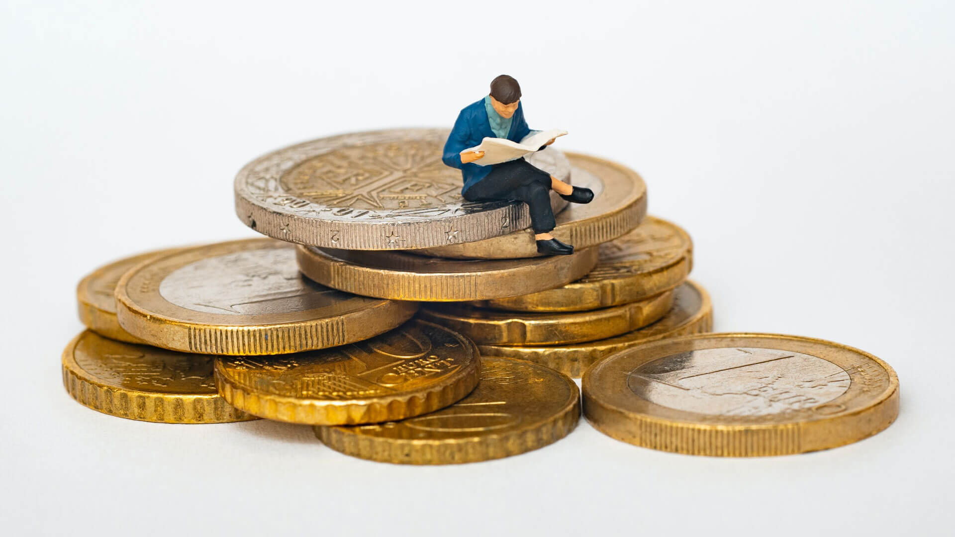 FI-Impact Boneco sentado em moedas de euro