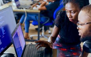 duas pessoas a olhar ecrã de computador