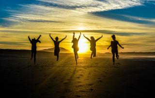 silhueta de jovens a saltar ao por do sol