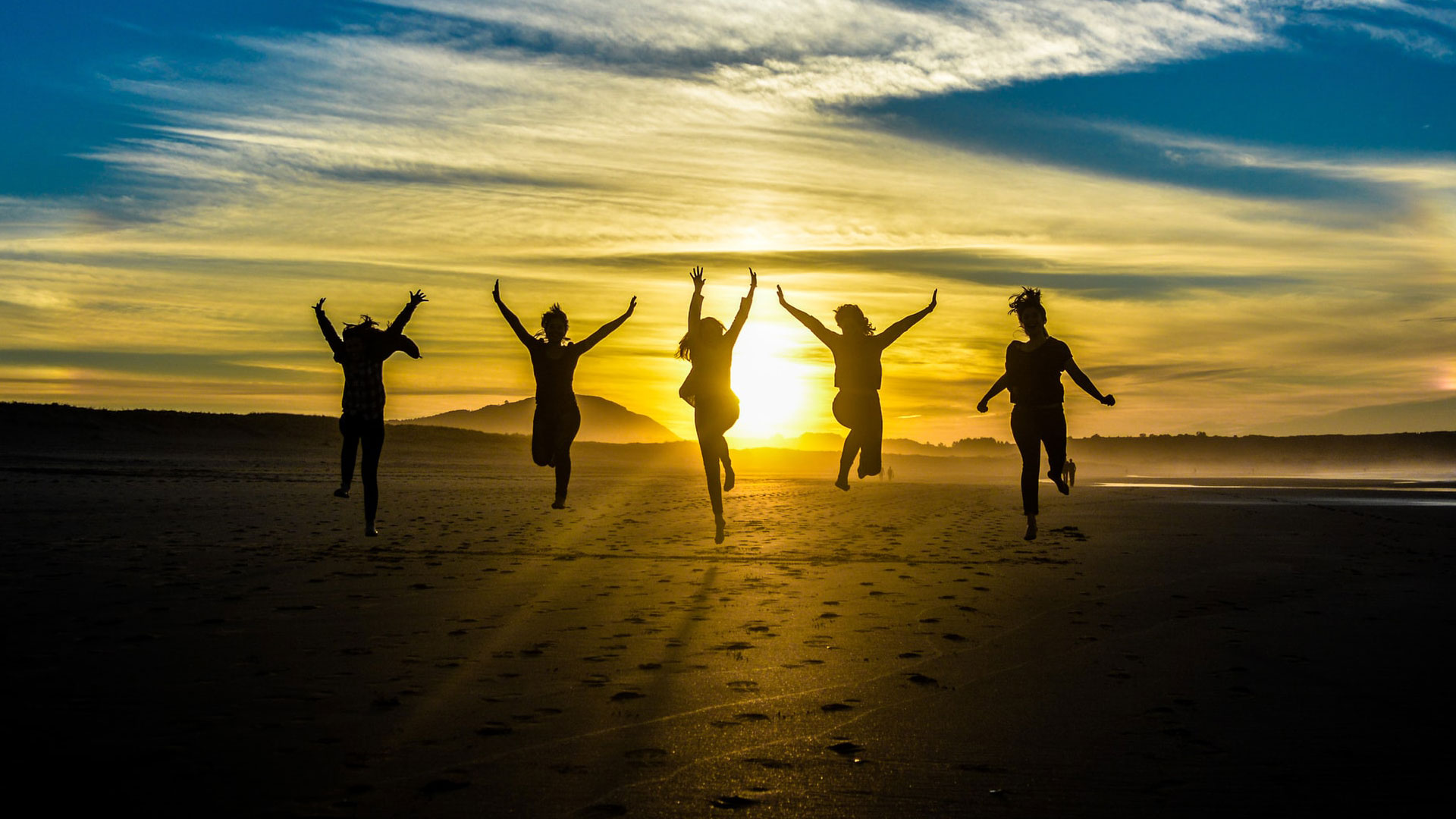 silhueta de jovens a saltar ao por do sol