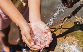 hands holding falling water