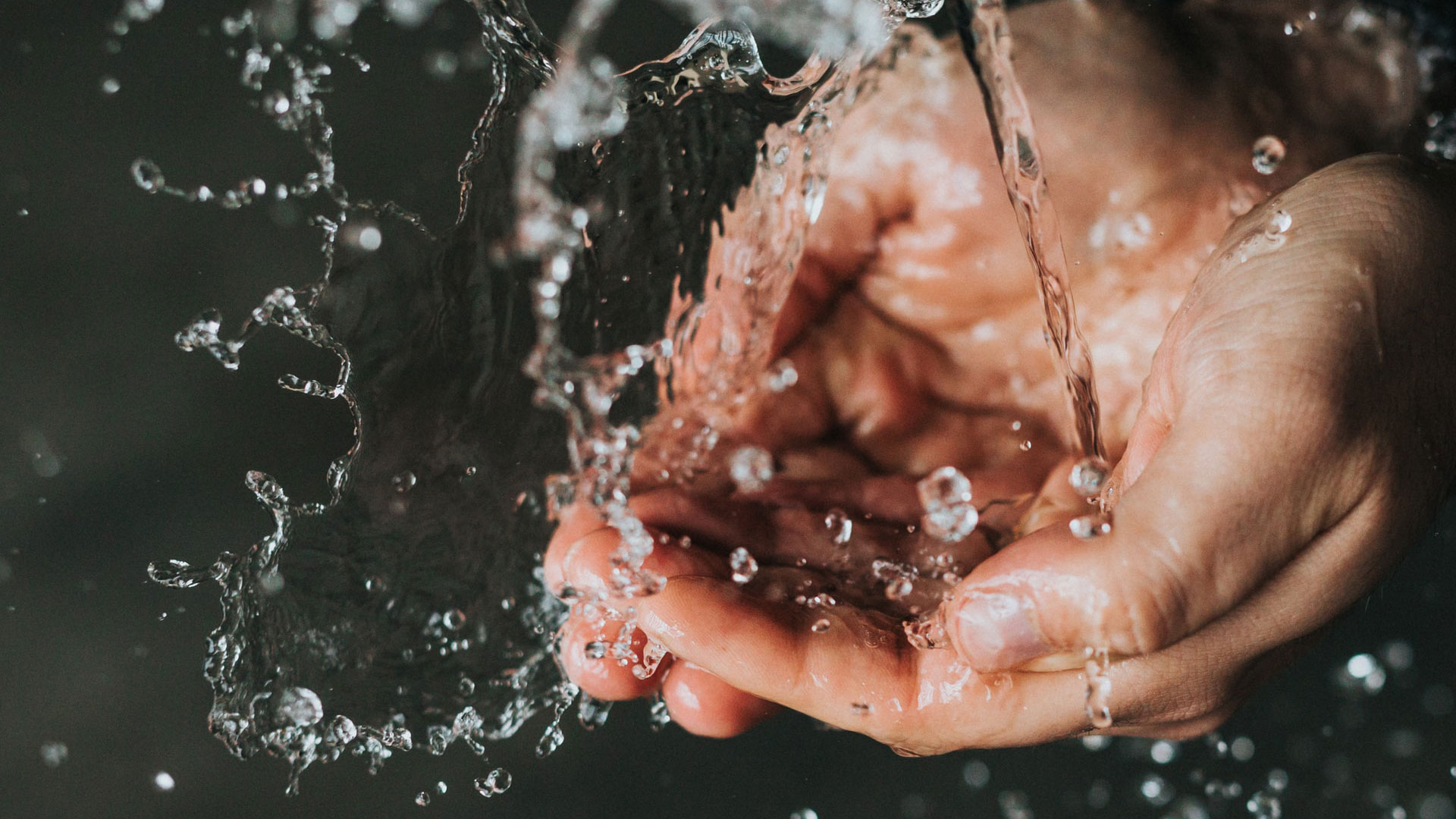 hands holding falling water