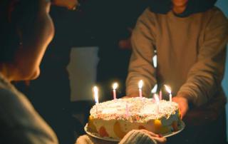 senhoras seguram bolo de aniversário