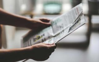 Pessoa a ler jornal