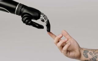 Mão humana estendida em direção a uma mão robótica