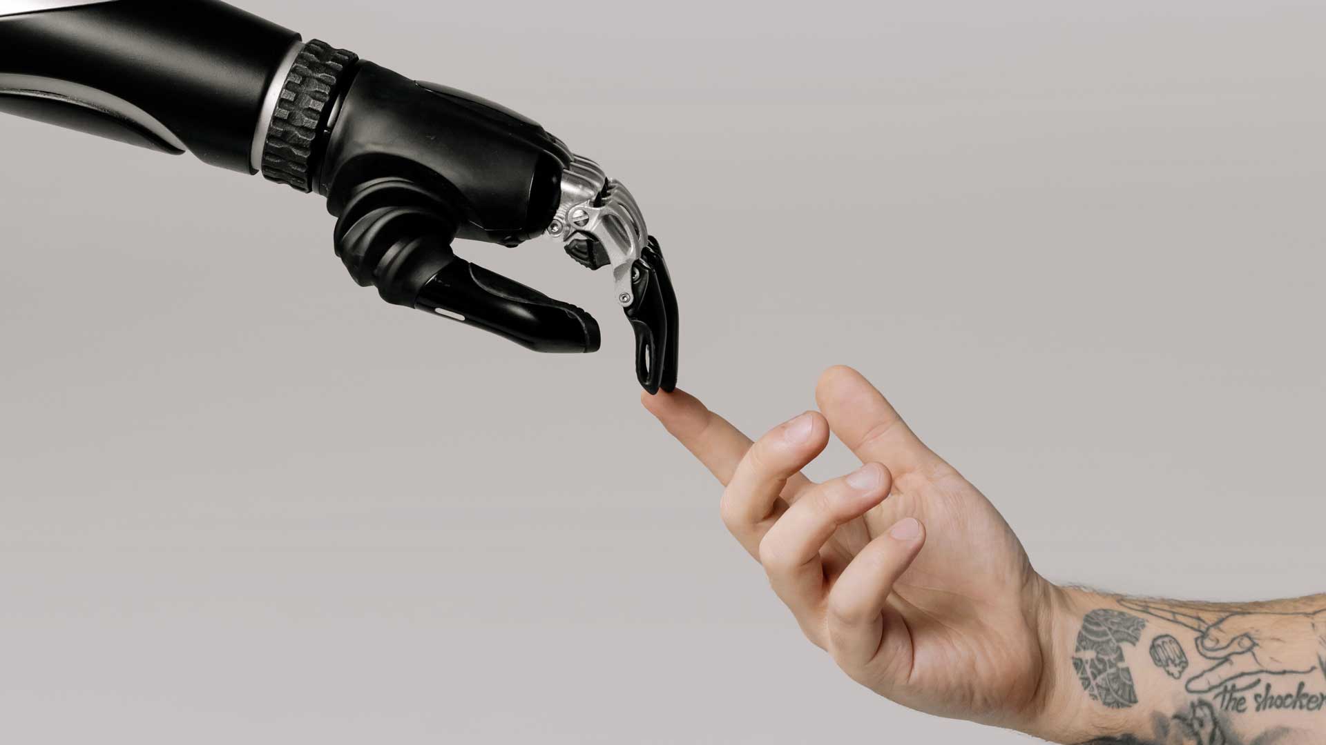 Mão humana estendida em direção a uma mão robótica